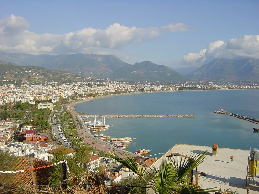 Alanya's seafront and bay seen from above, with the Taurus Mountains behind.