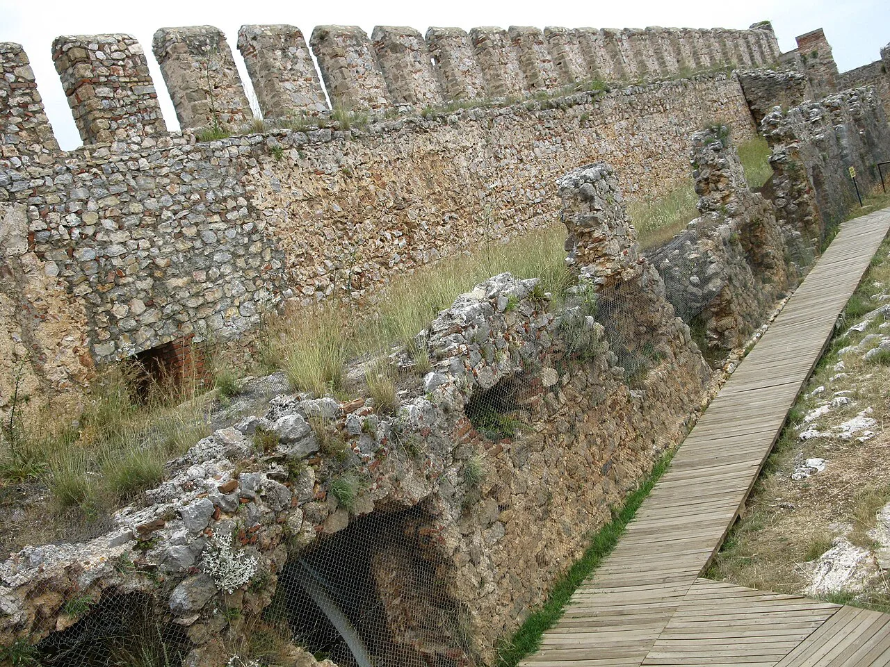 A boardwalk beside the ruined walls of Alanya Castle.