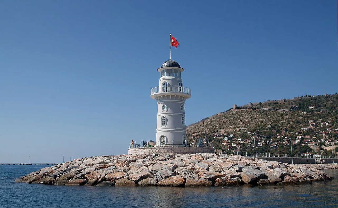 The white Alanya lighthouse on its rocky breakwater.