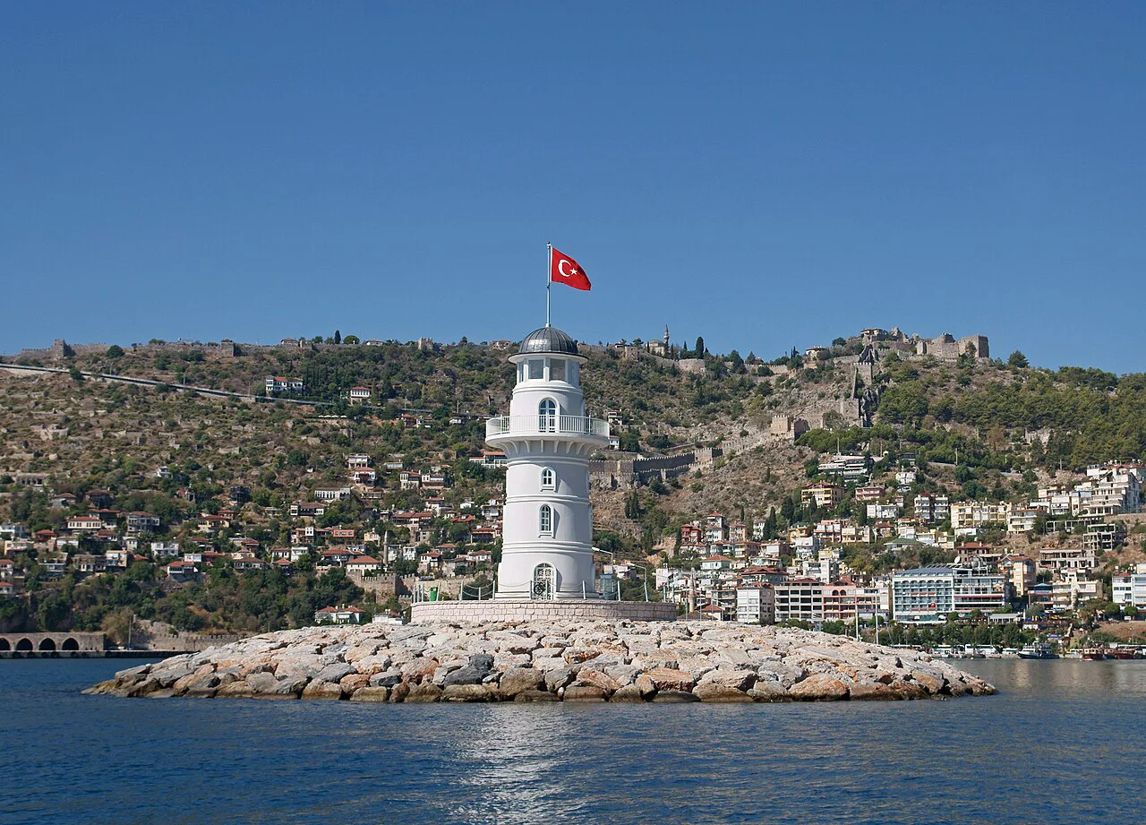 The Alanya lighthouse at the end of its breakwater, with the town behind.