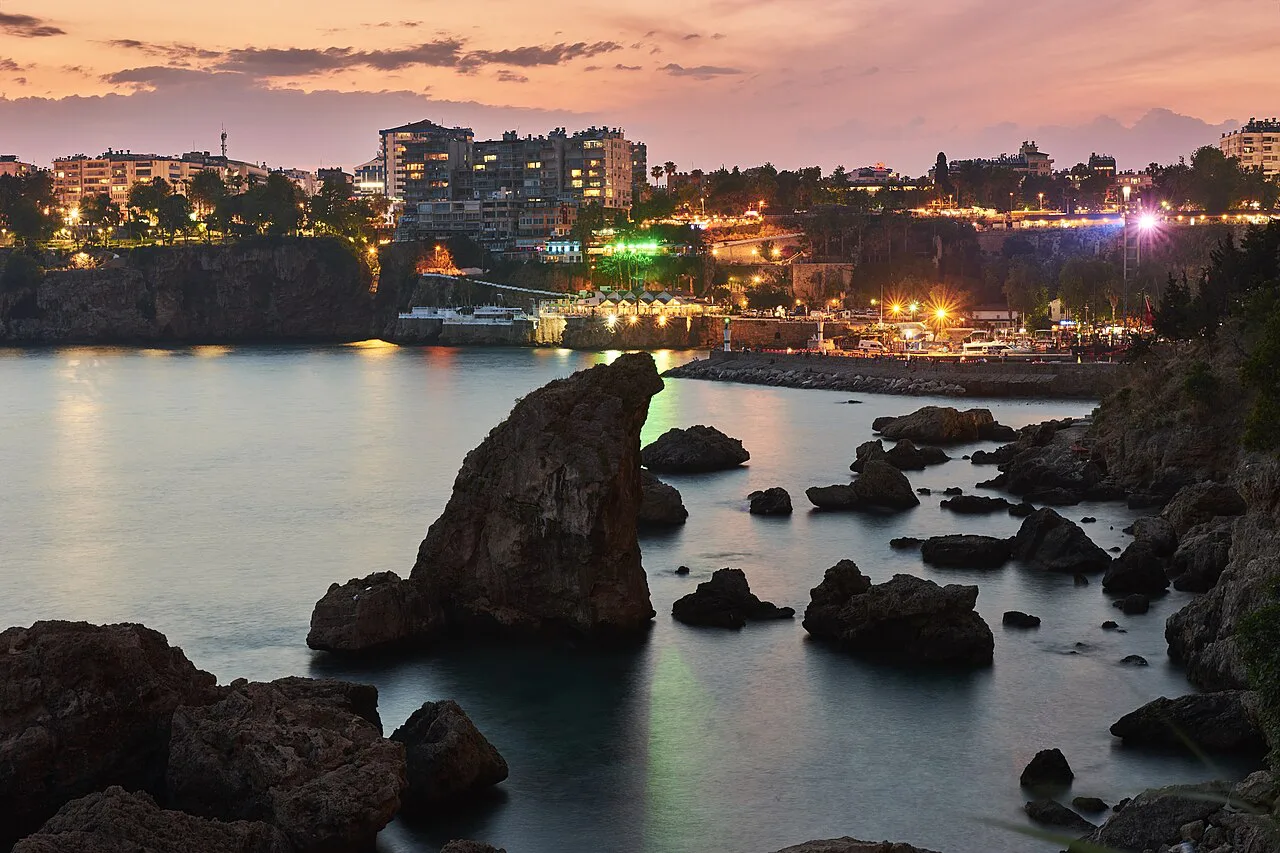 Antalya's harbour and seafront lit up in the evening.