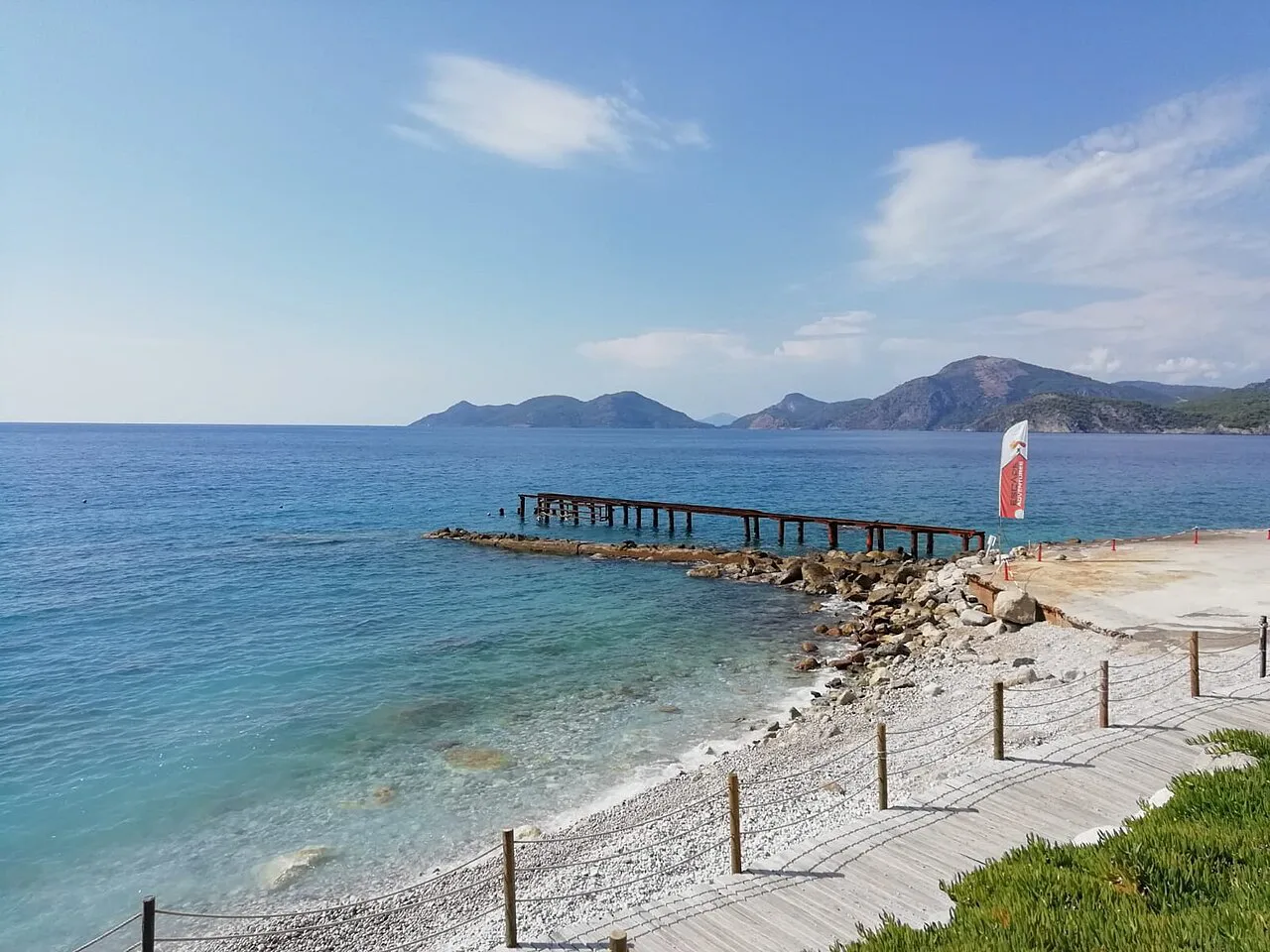 A wooden jetty running out from the pebble beach at Ölüdeniz.