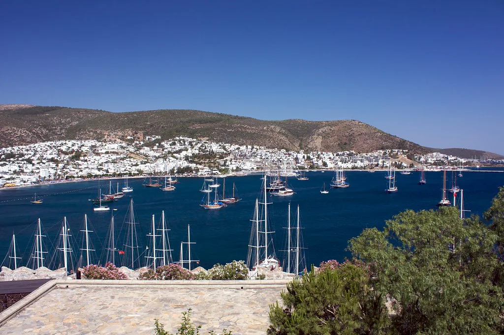 Bodrum bay with yachts in the marina and white houses on the hills behind.