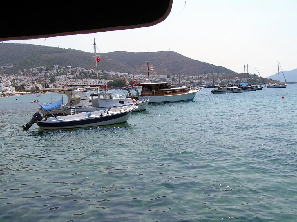 Boats in Bodrum bay with the town spread along the shore.