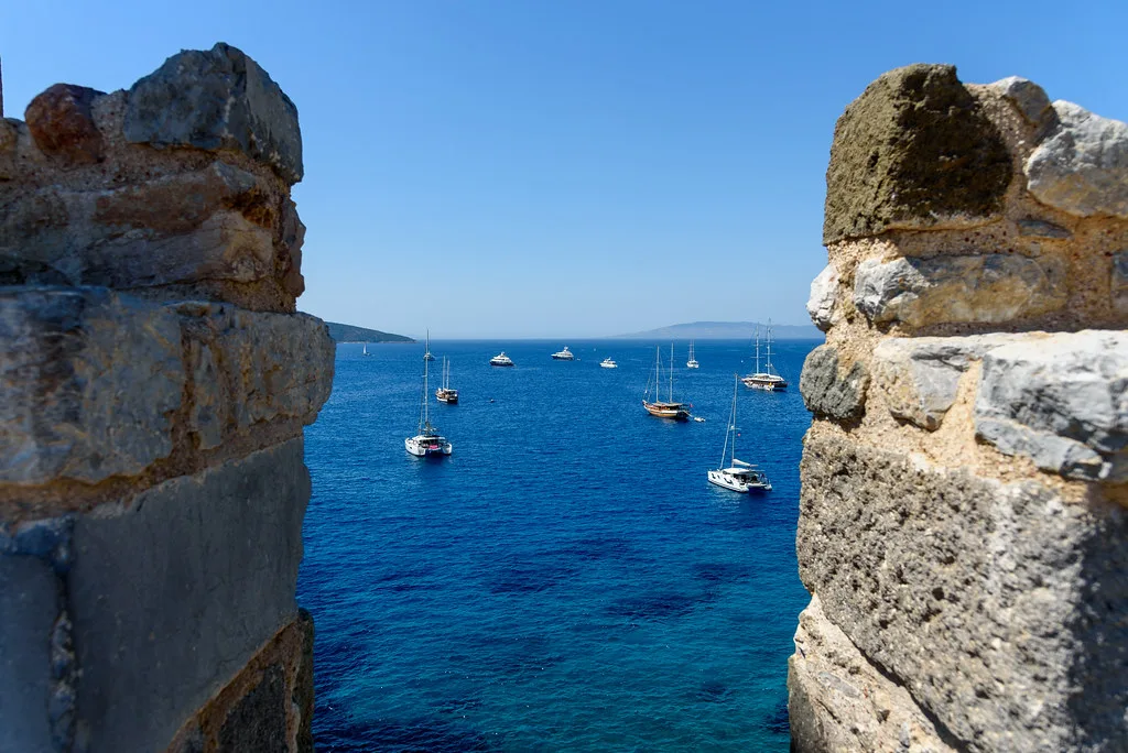 Yachts anchored in the bay off Bodrum, framed by old stone battlements.