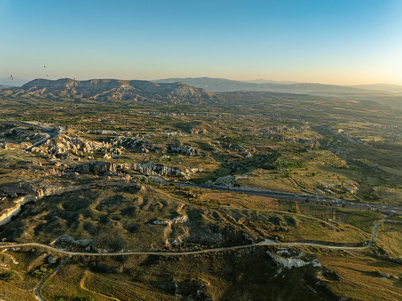 Cappadocia's valleys and plateaus seen from the air in golden light.