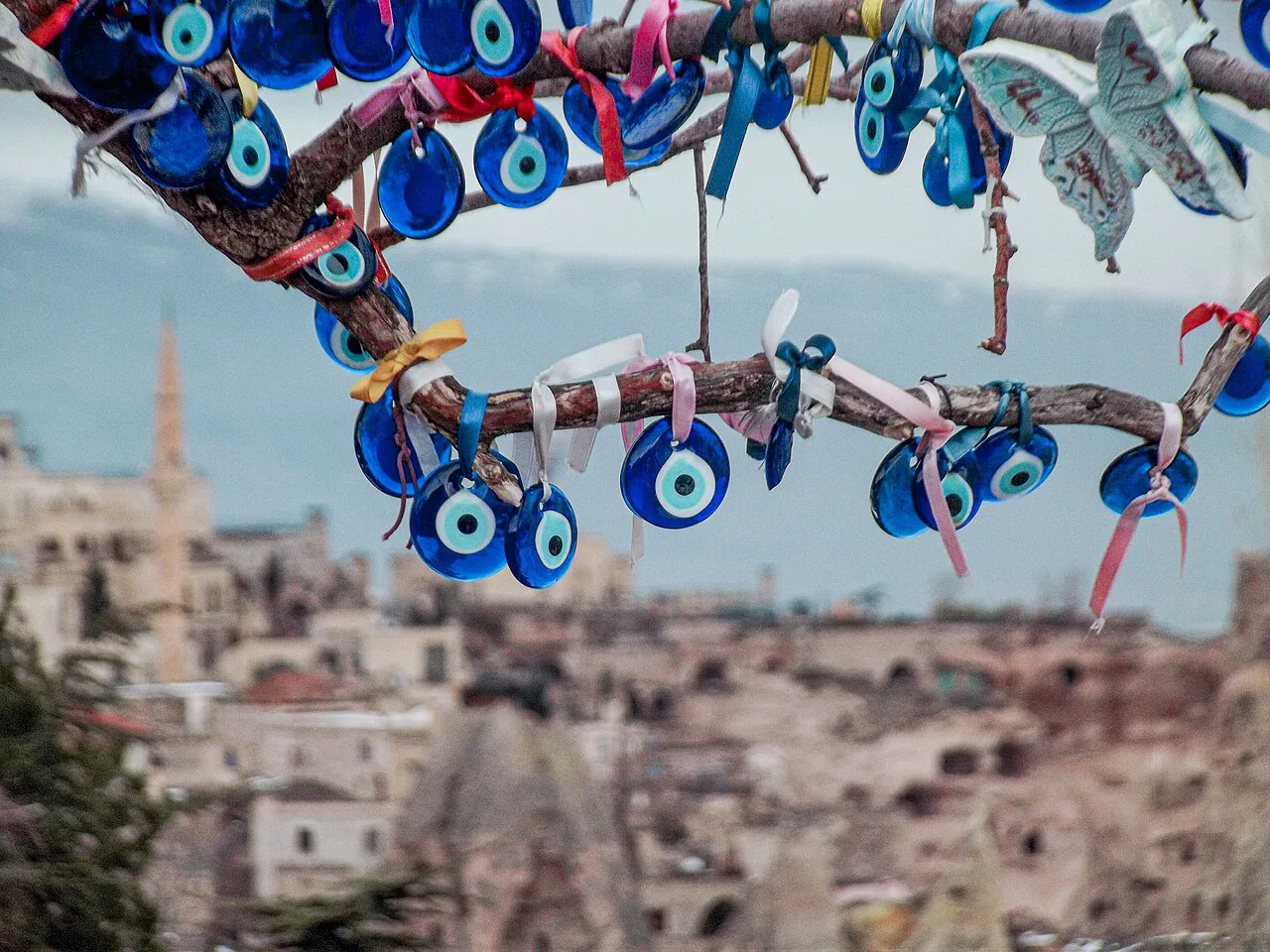 Evil eye beads hanging from a tree above a Cappadocia village.