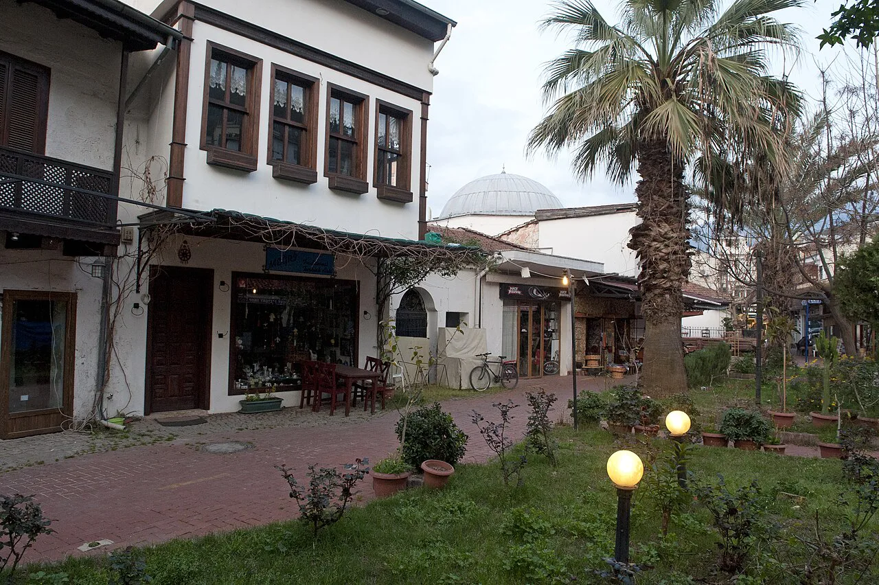 Old-style houses and shopfronts beside a small garden in Fethiye.