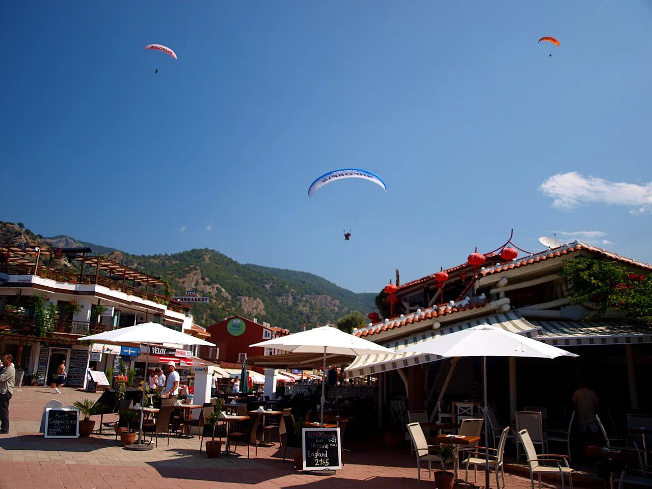 Paragliders coming in to land over the seafront restaurants at Ölüdeniz.