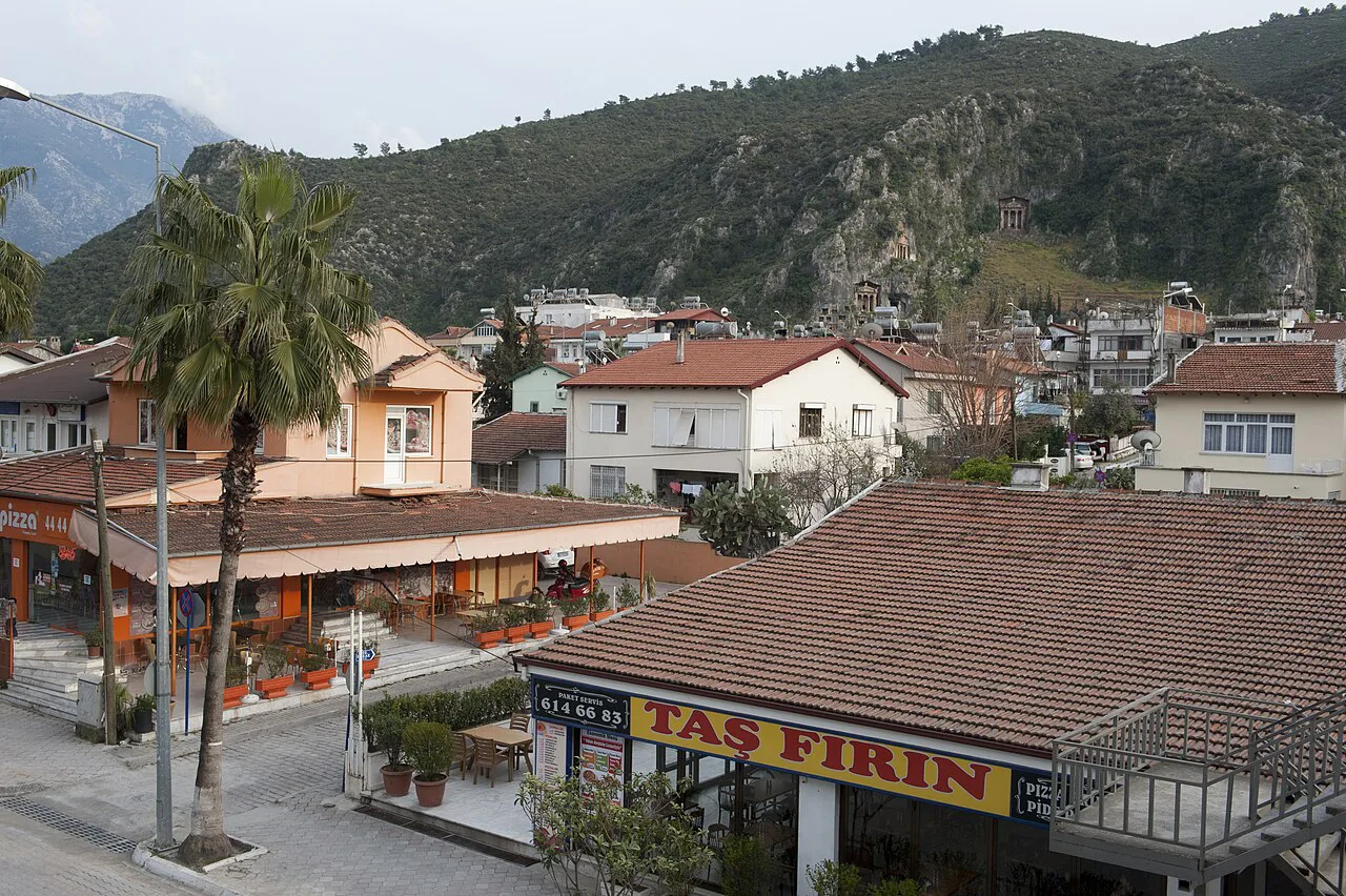 A stone-oven bakery and street-side cafés in Fethiye, with rock tombs on the hillside above.