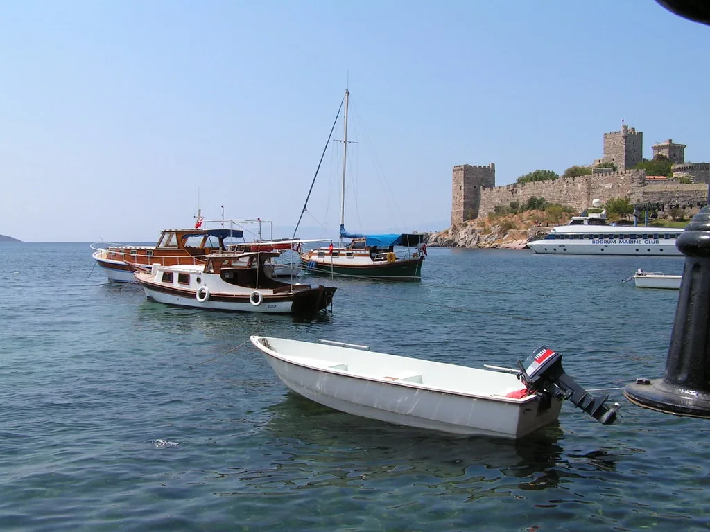 Boats moored in Bodrum harbour with Bodrum Castle behind, a short hop from Gümbet.