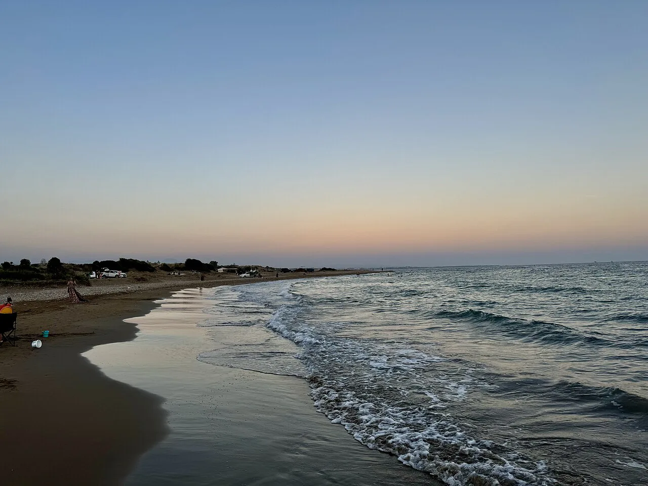 A long sandy beach on the Manavgat coast at dusk.