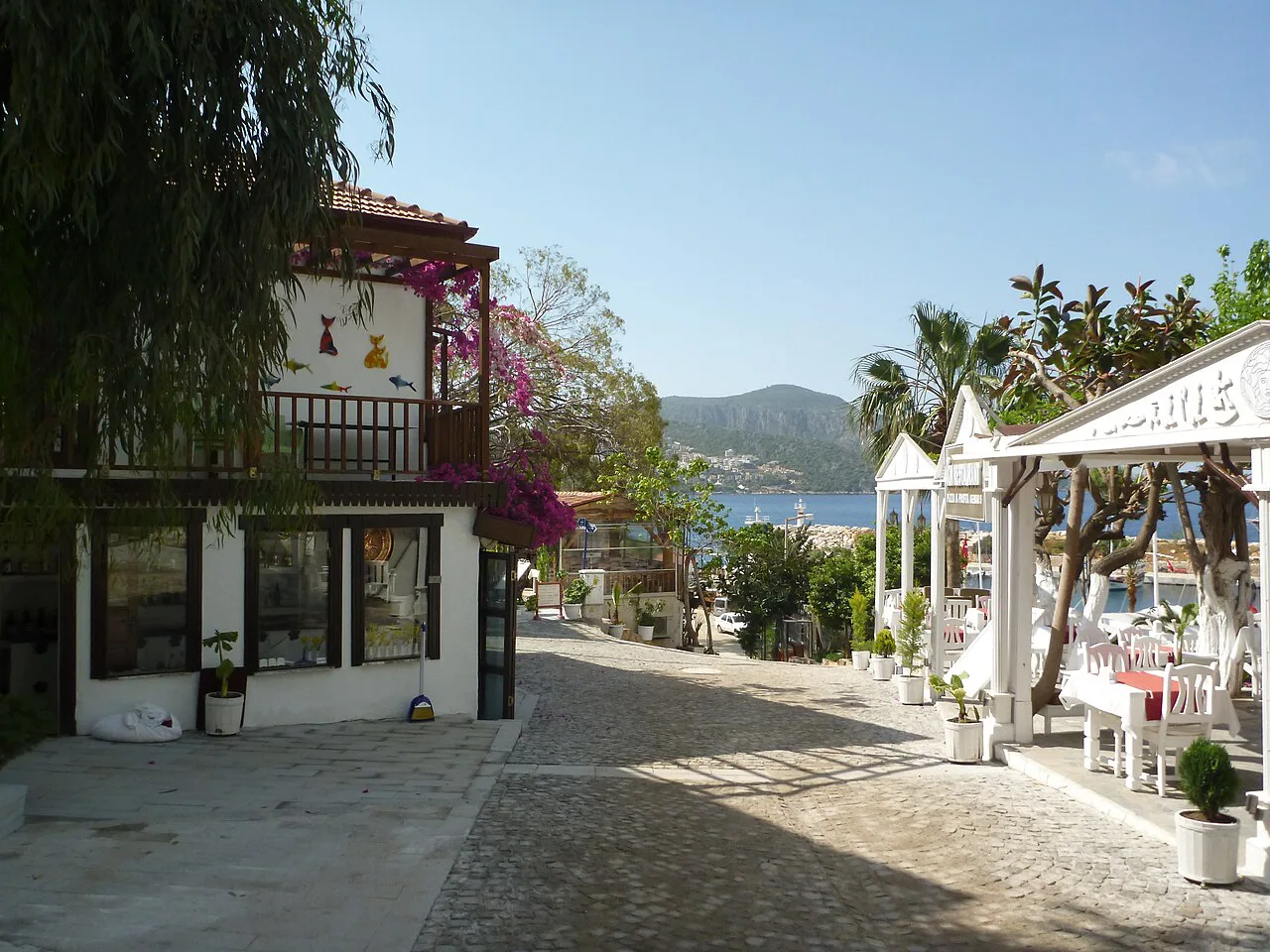 A typical whitewashed street in Kalkan with bougainvillea and restaurant terraces.