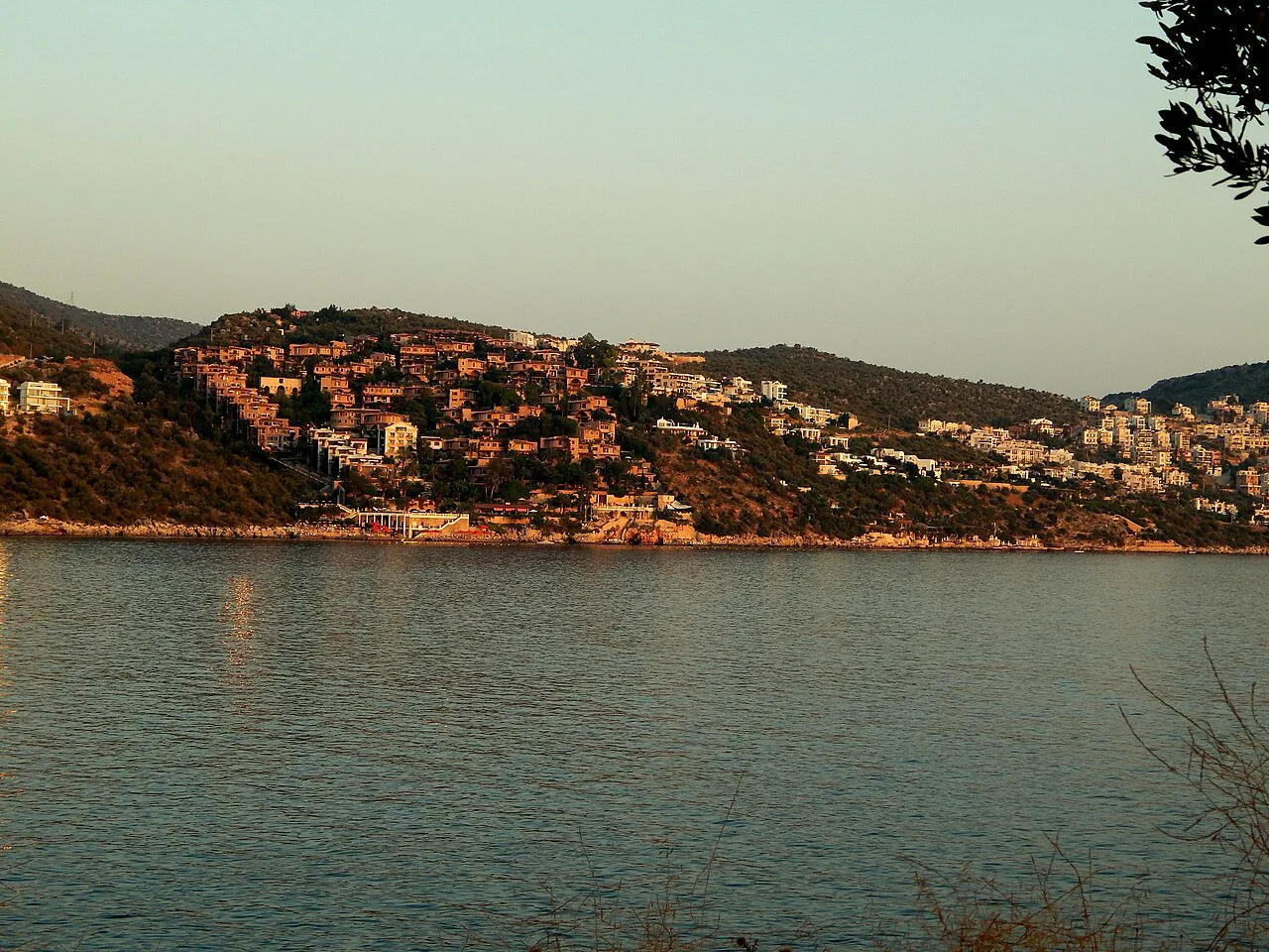 Kalkan's hillside houses across the bay at sunset.