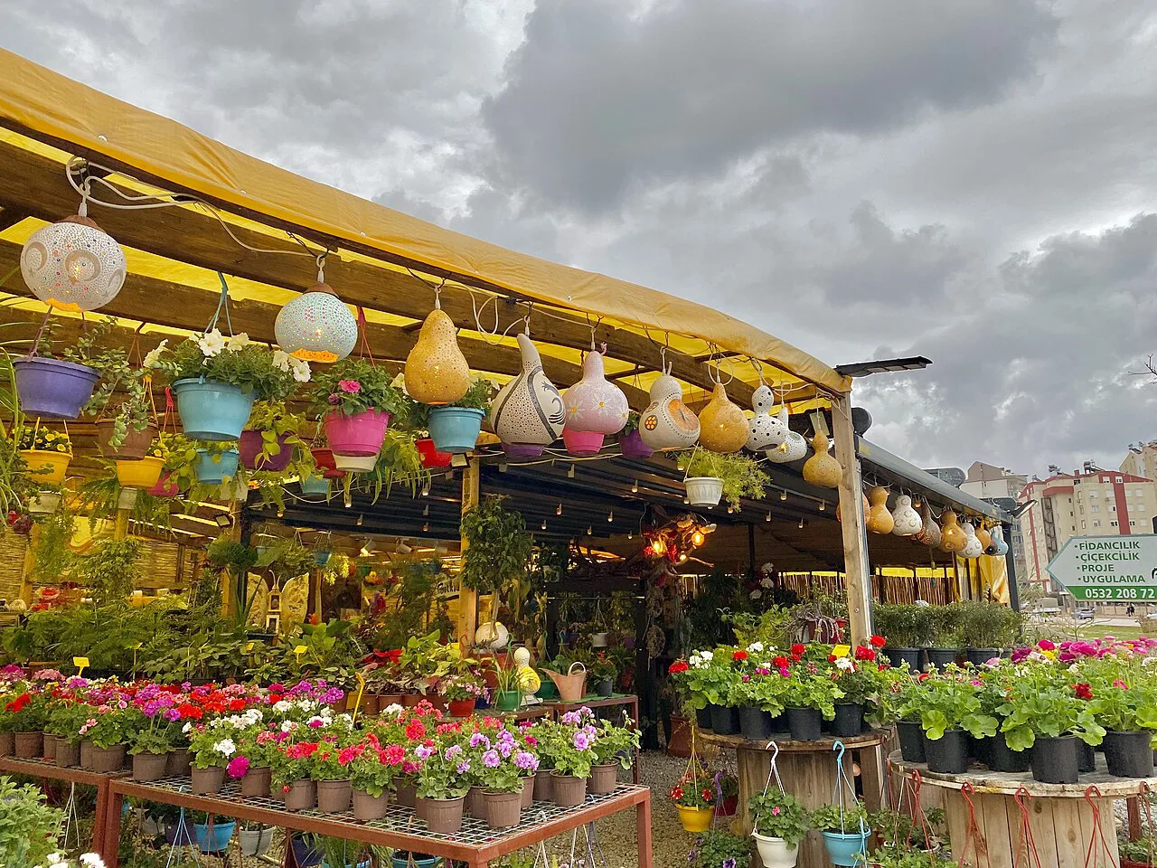 A café decorated with flowers and hanging lamps in Konyaaltı.