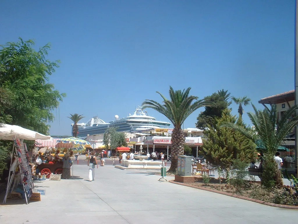 Kuşadası waterfront with a cruise ship docked in the port.