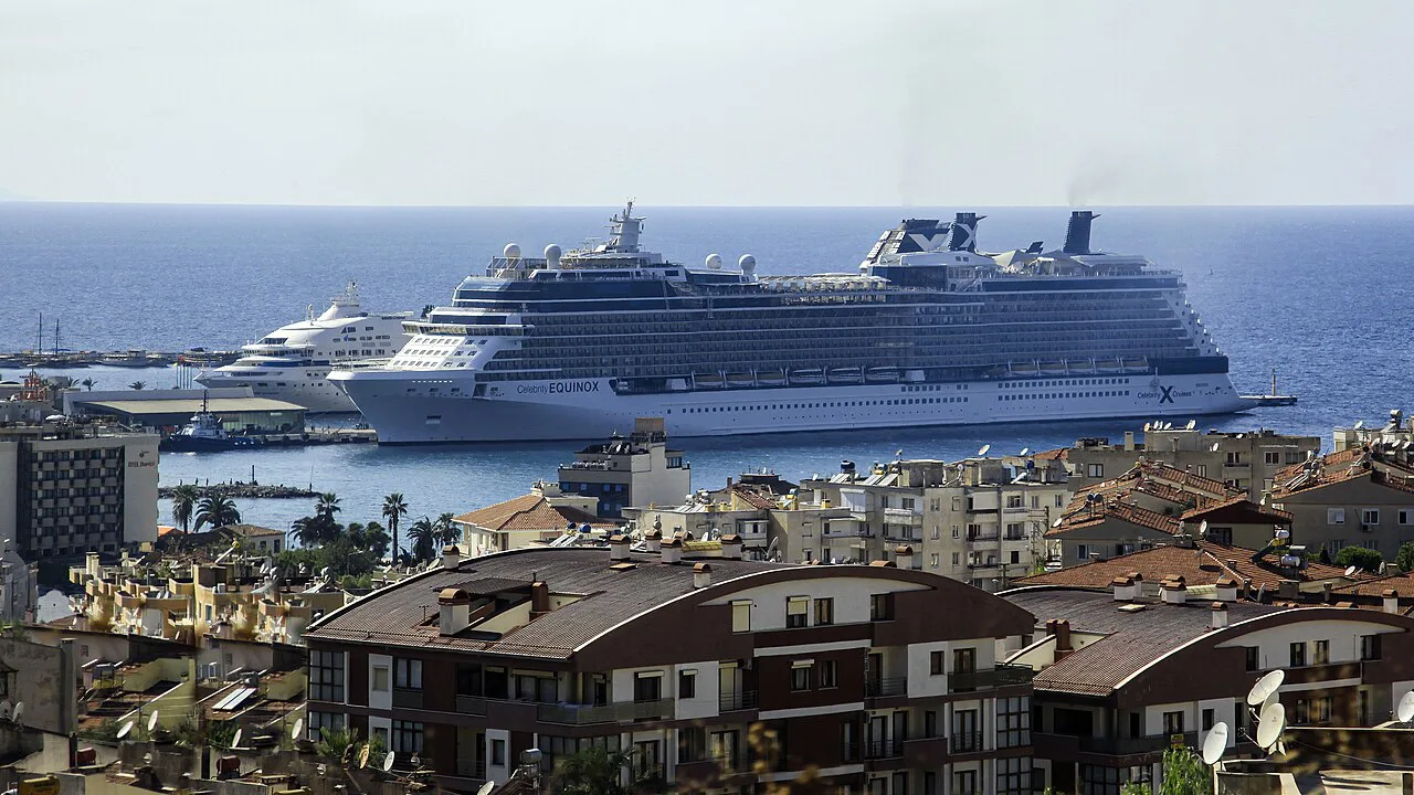 A cruise ship docked at Kuşadası port beyond the town's rooftops.