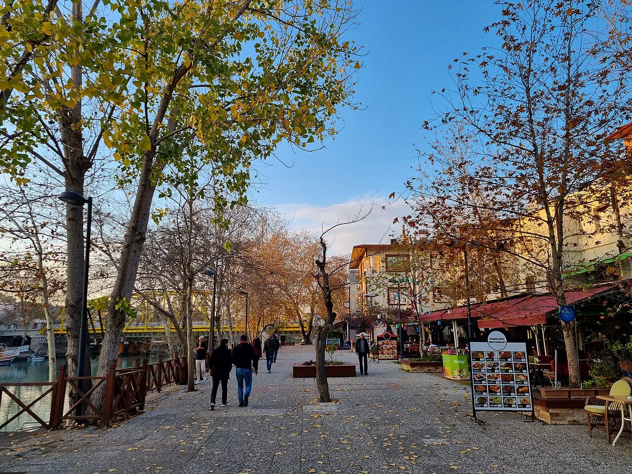 A tree-lined pedestrian street with cafés in Manavgat.