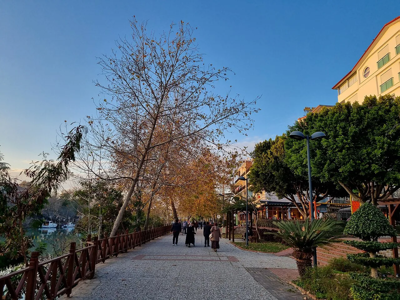 A tree-lined riverside walkway in Manavgat.
