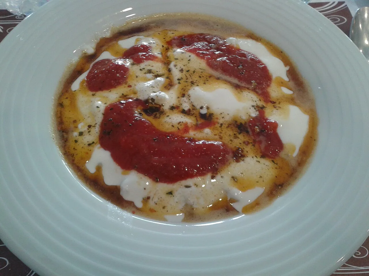 A plate of mantı topped with yoghurt and red pepper butter in Ankara.