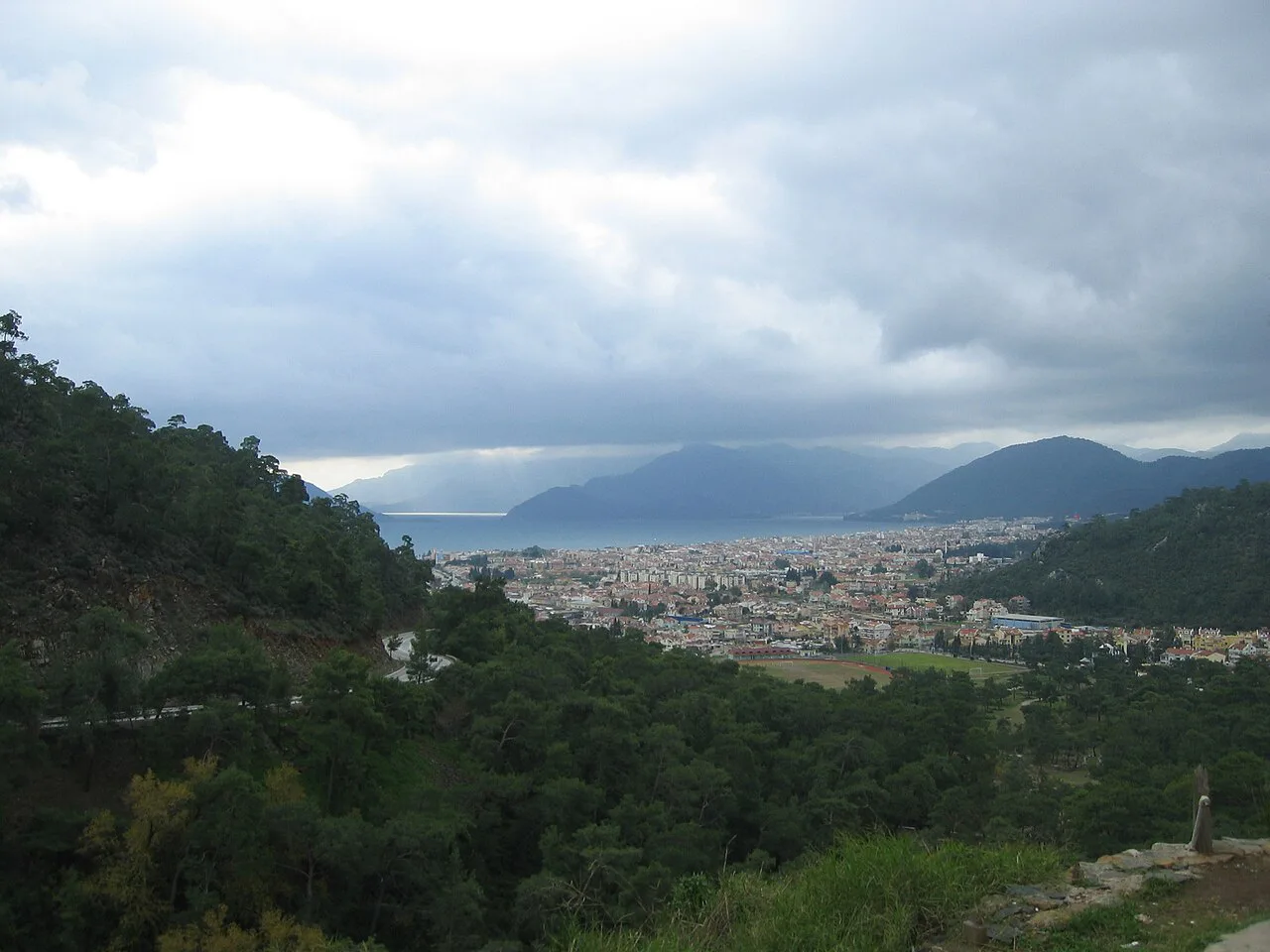 Marmaris and its bay seen from a forested hillside.