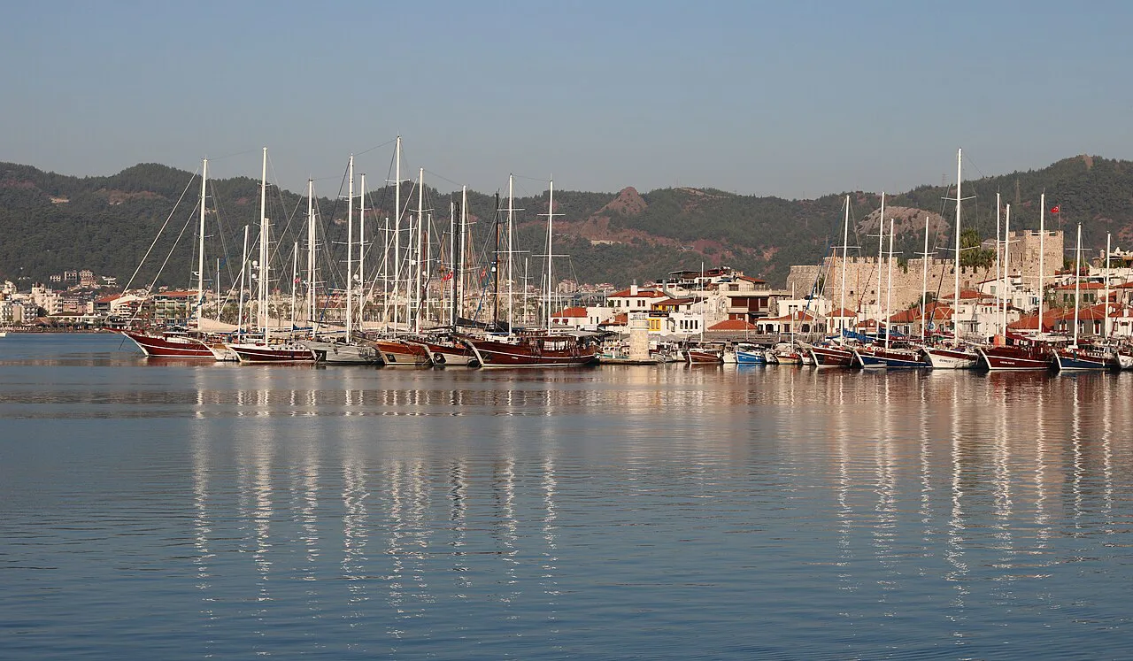 Yachts in Marmaris marina reflected in calm water.