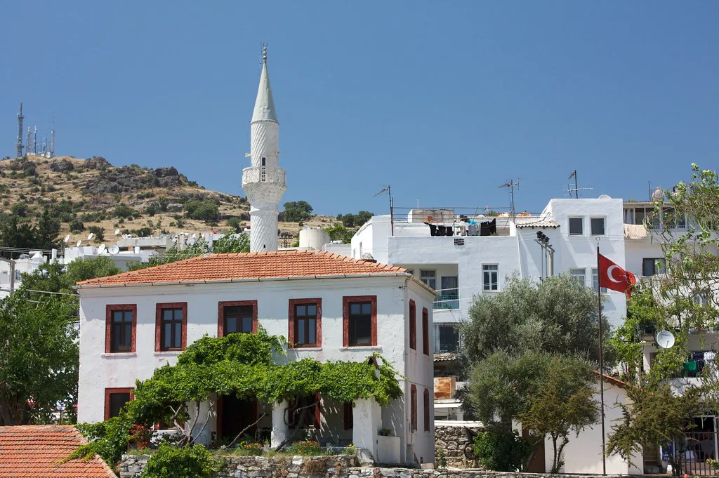 A mosque minaret rising above white houses in Bodrum near the Mausoleum.