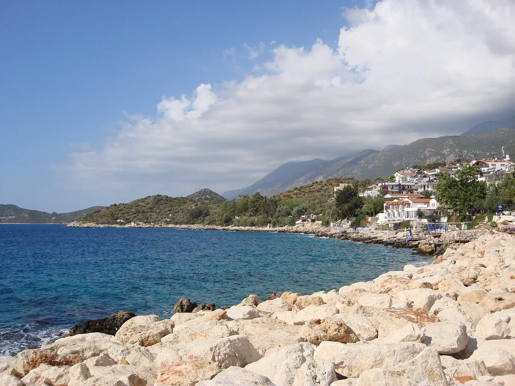 The rocky shoreline at Kaş with the town on the hillside beyond.