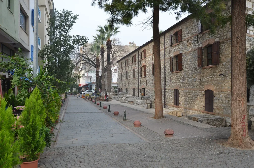 A cobbled side street lined with old stone houses in Kuşadası.