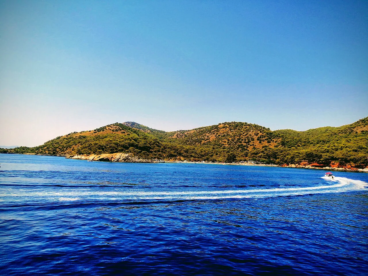 A boat speeding across the bay at Ölüdeniz.