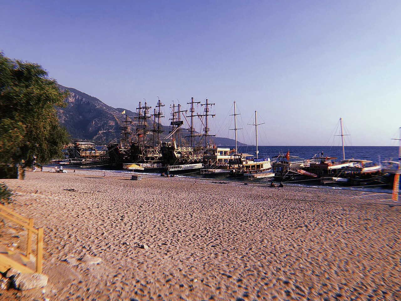 Tour boats moored off the sandy beach at Ölüdeniz.