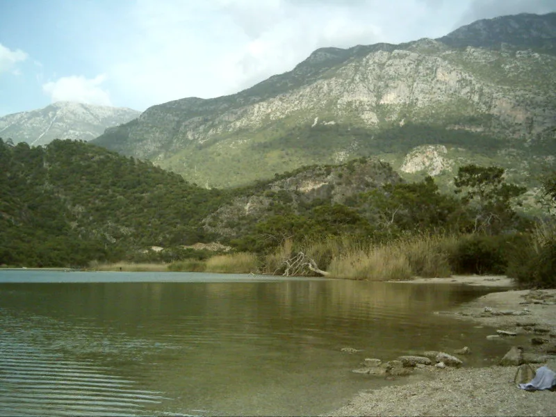The shallow lagoon at Ölüdeniz beneath forested mountains.