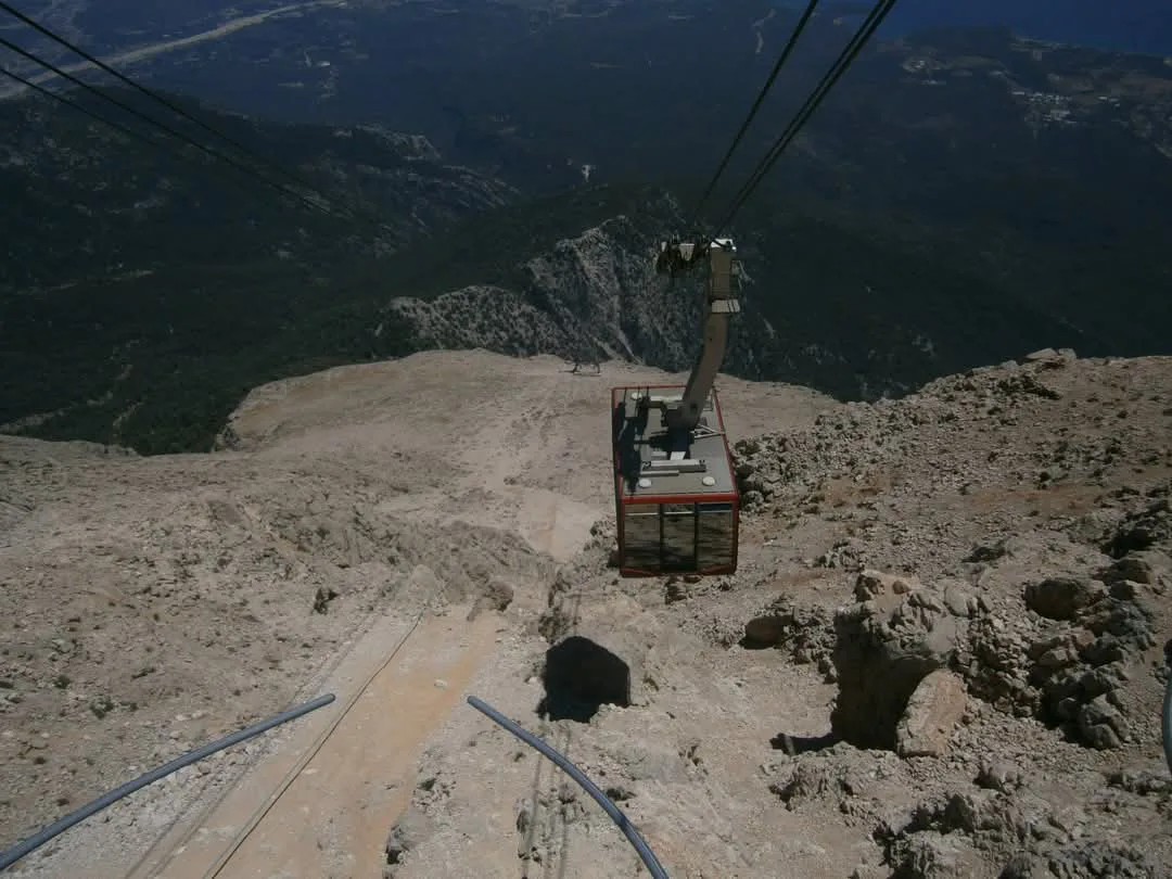 A cabin of the Olympos aerial tramway above the rocky mountainside in Antalya Province.