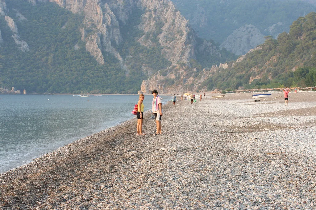 The pebble beach at Olympos framed by steep mountains.