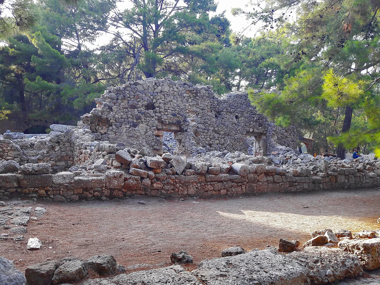 Stone ruins at Phaselis surrounded by pine forest.