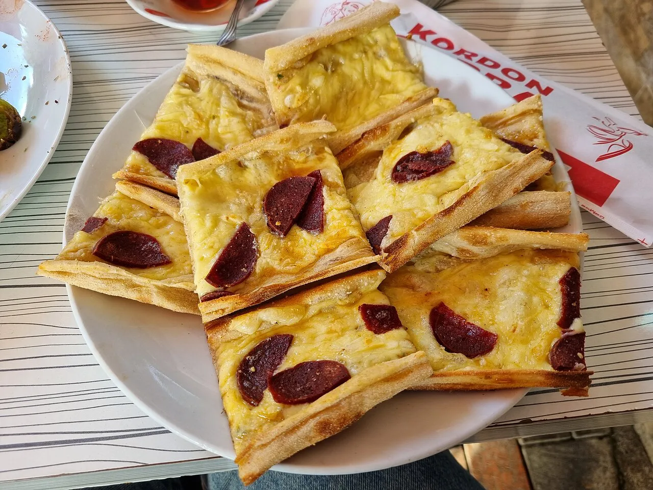 Sliced Turkish pide with cheese and sucuk.