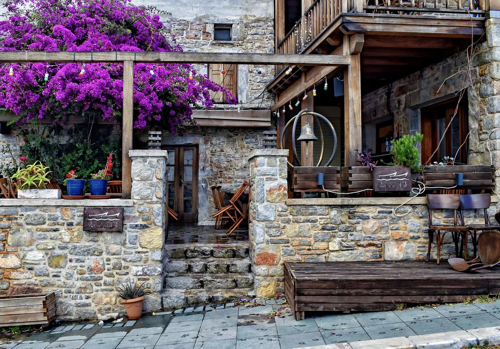 A stone café building draped in bougainvillea in Bodrum.
