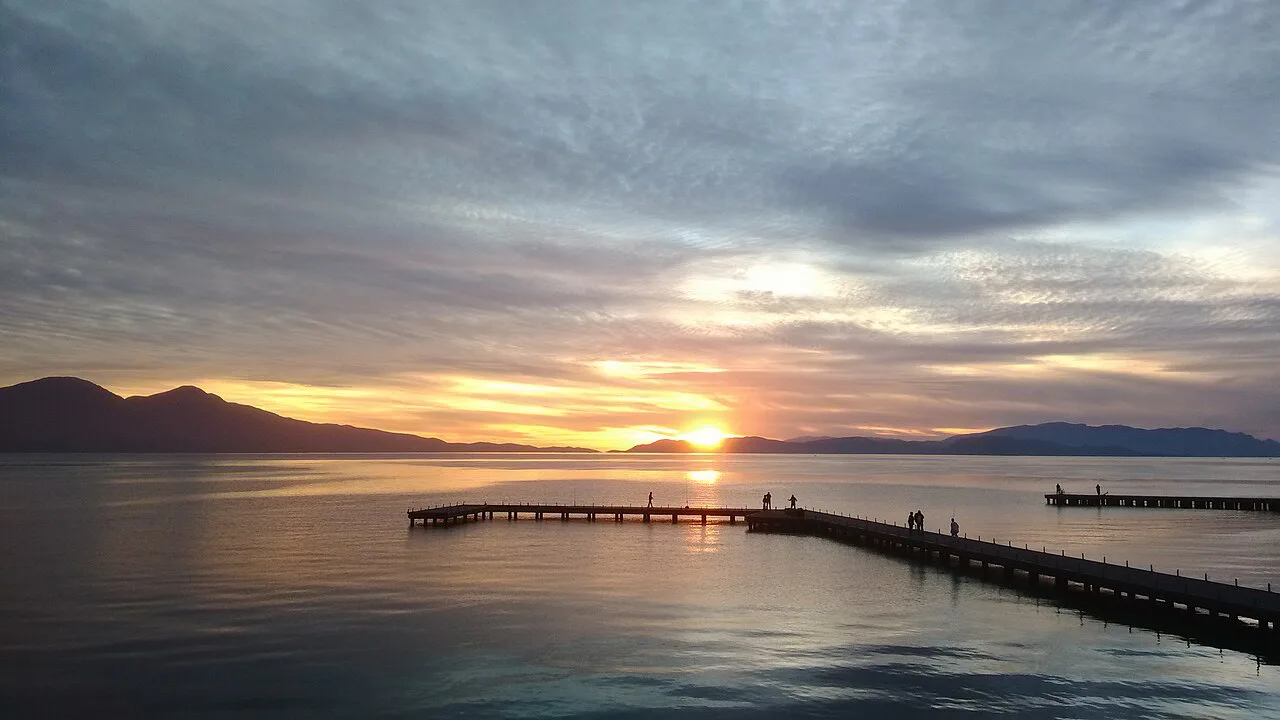 Sunset over the sea at Kuşadası with a pier in the foreground.