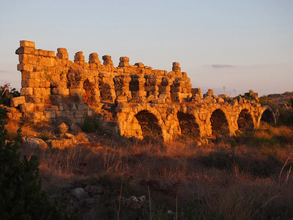 Ancient ruins in Side lit by the setting sun.