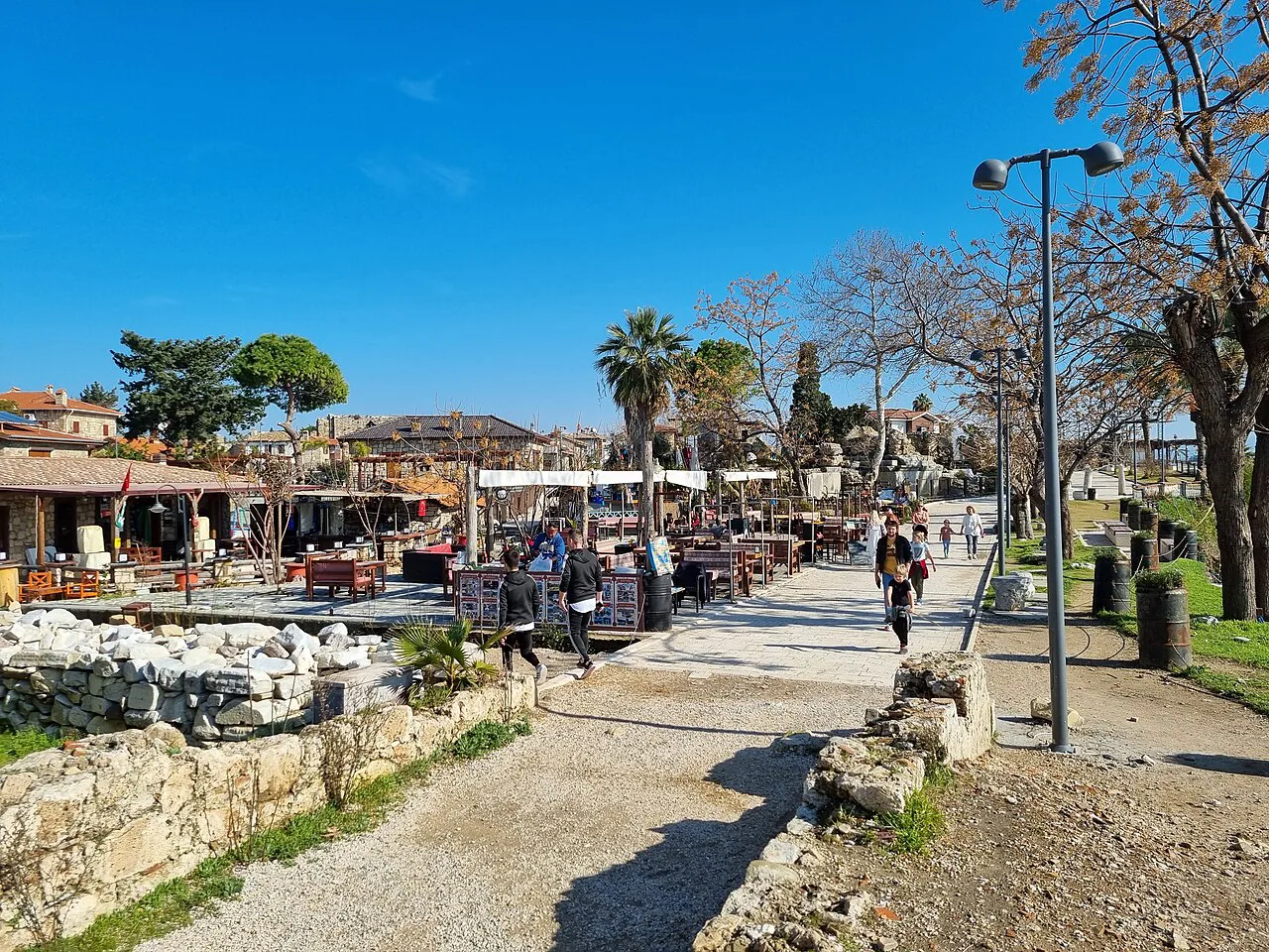 The harbourside promenade in Side lined with ancient stone blocks and restaurants.