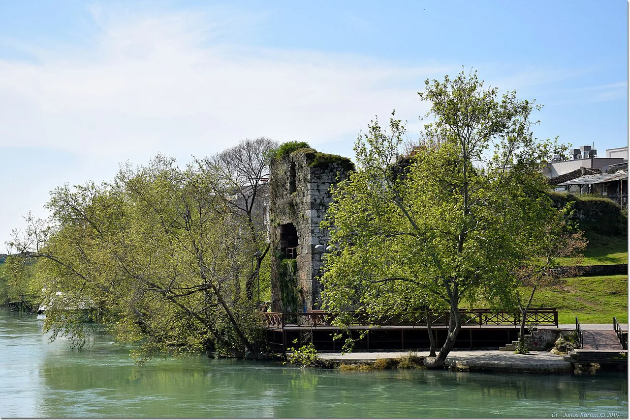 An old stone ruin among trees on the bank of the Manavgat River.