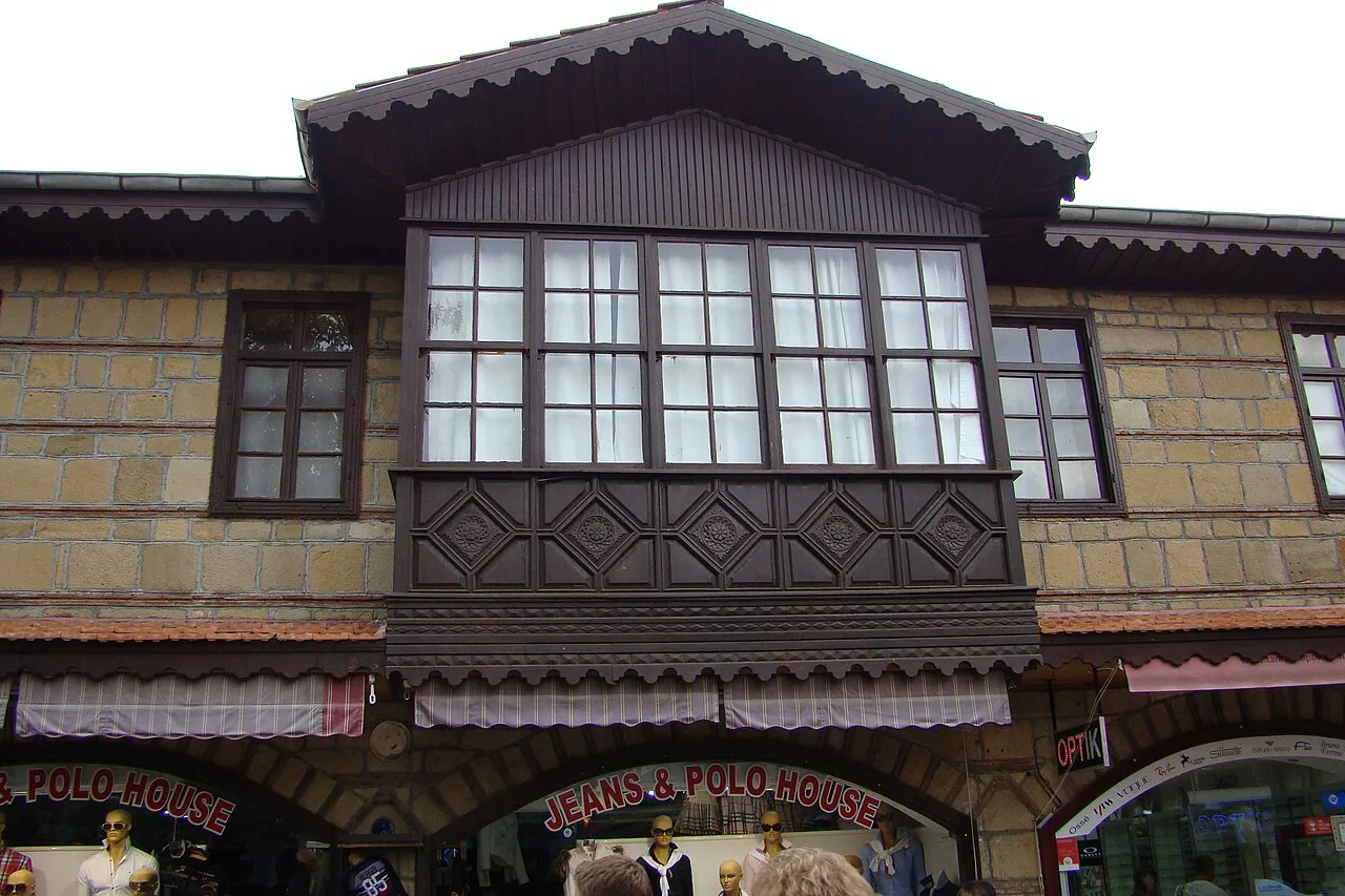 A traditional house with a timber bay window above shops in Side.