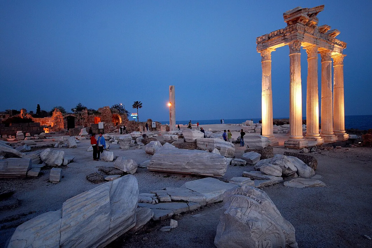 The Temple of Apollo floodlit at dusk by the harbour in Side.
