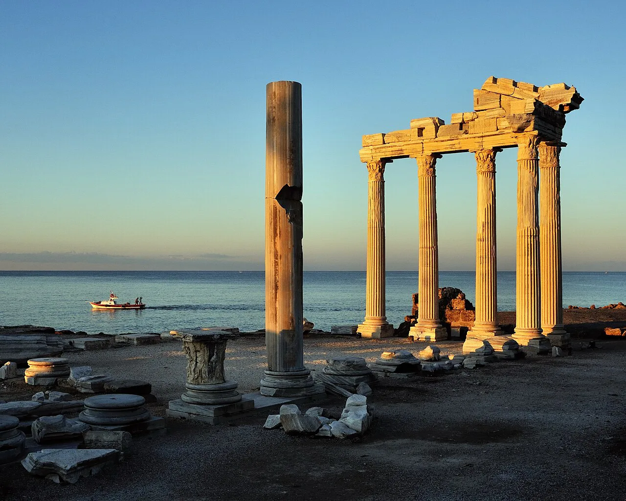 The Temple of Apollo at Side at dusk, with a boat out at sea.