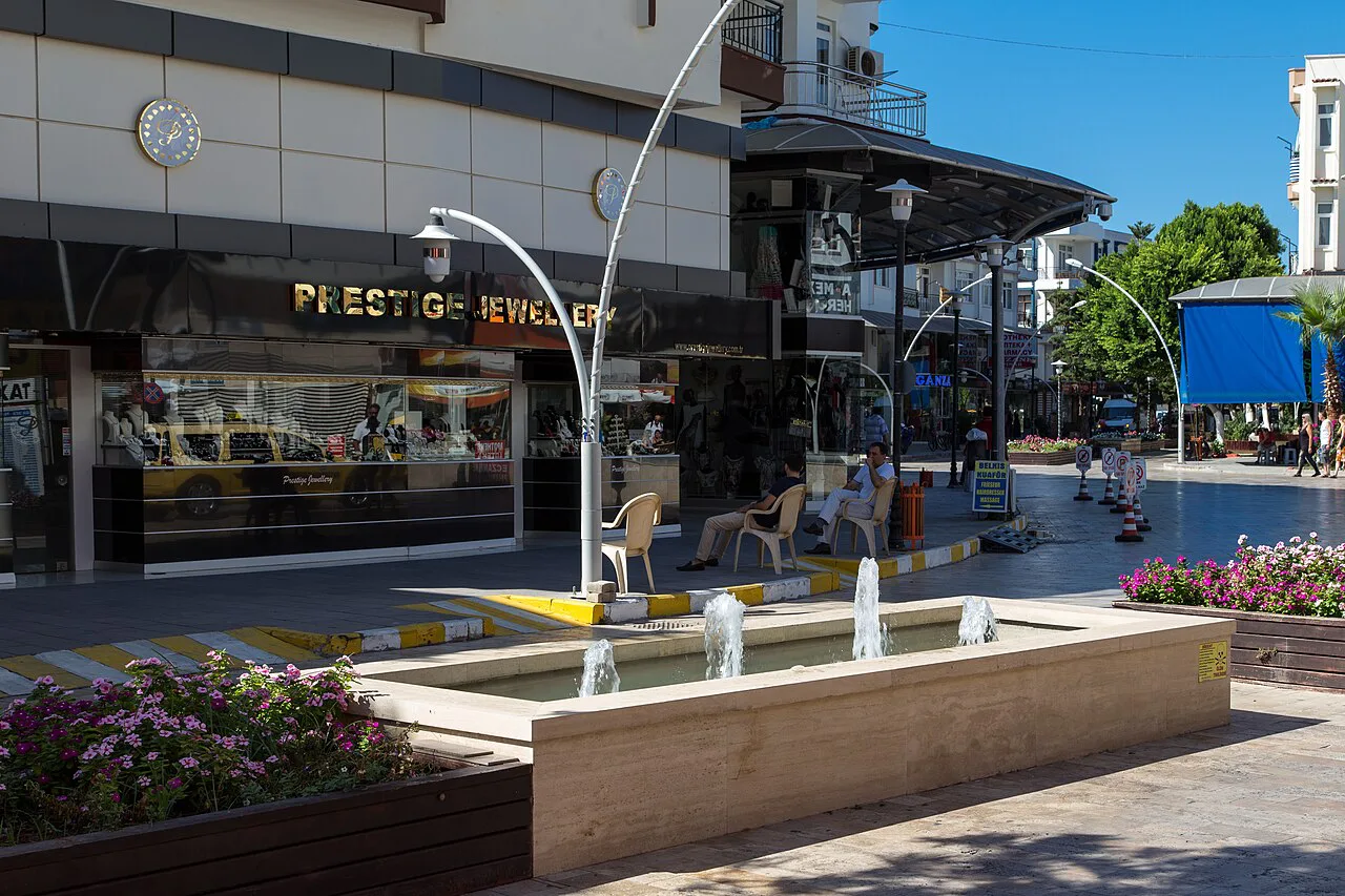 A fountain and shopfronts on a street in Belek.