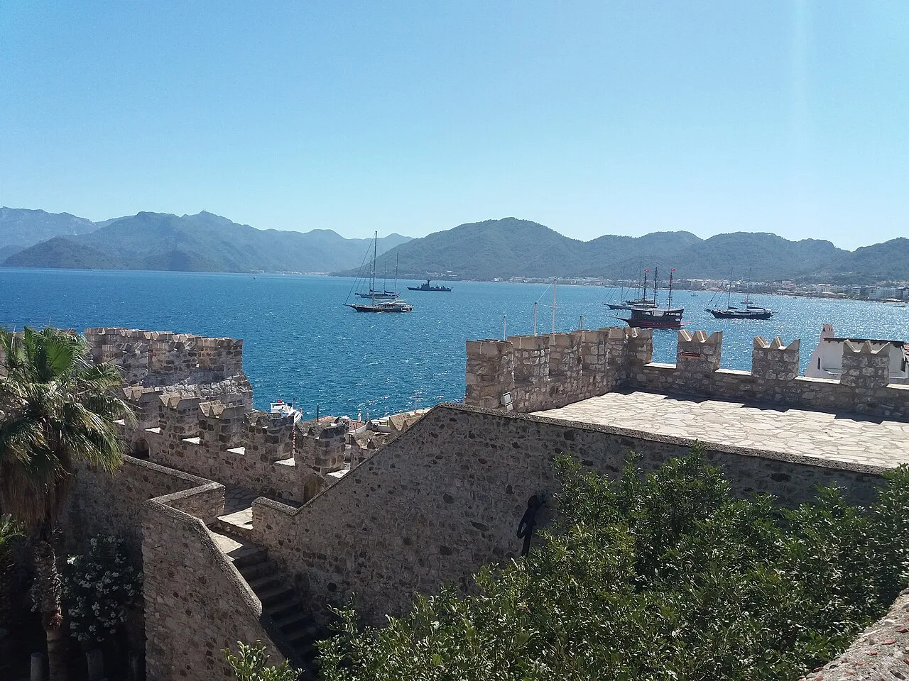 The walls of Marmaris Castle above the bay and moored boats.