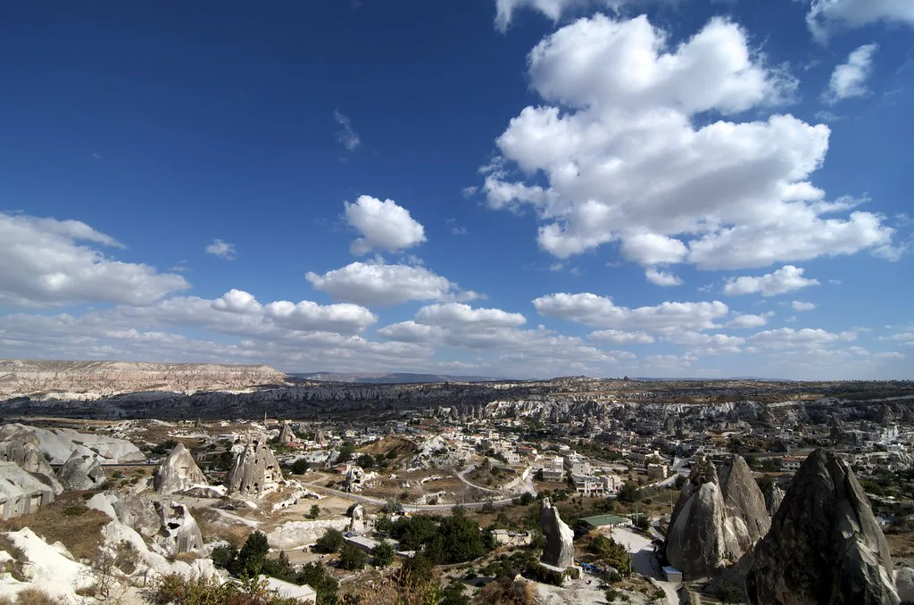 Göreme and the surrounding rock formations of Cappadocia under a blue sky.