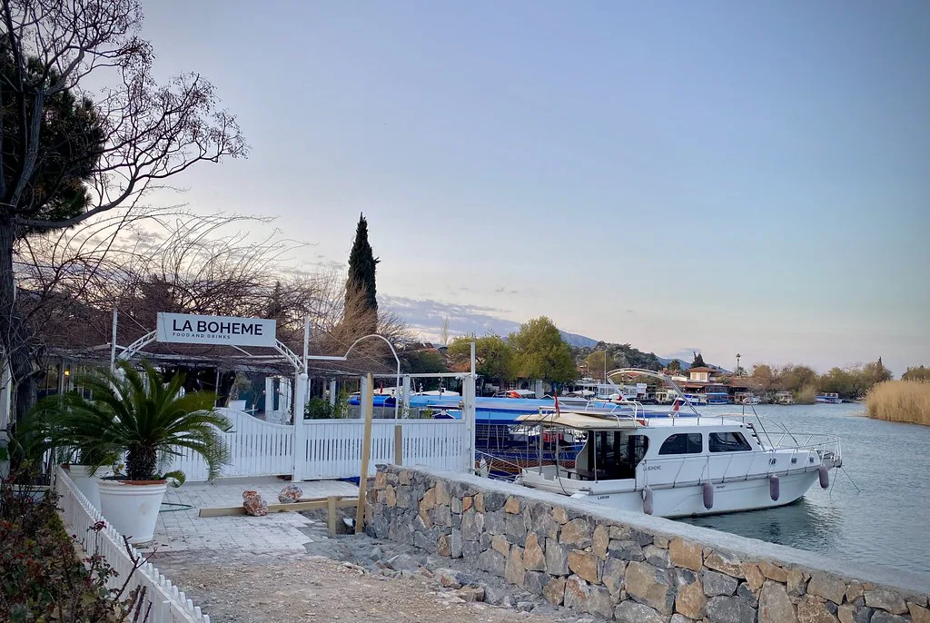 Boats moored on the Dalyan River beside a waterside restaurant.