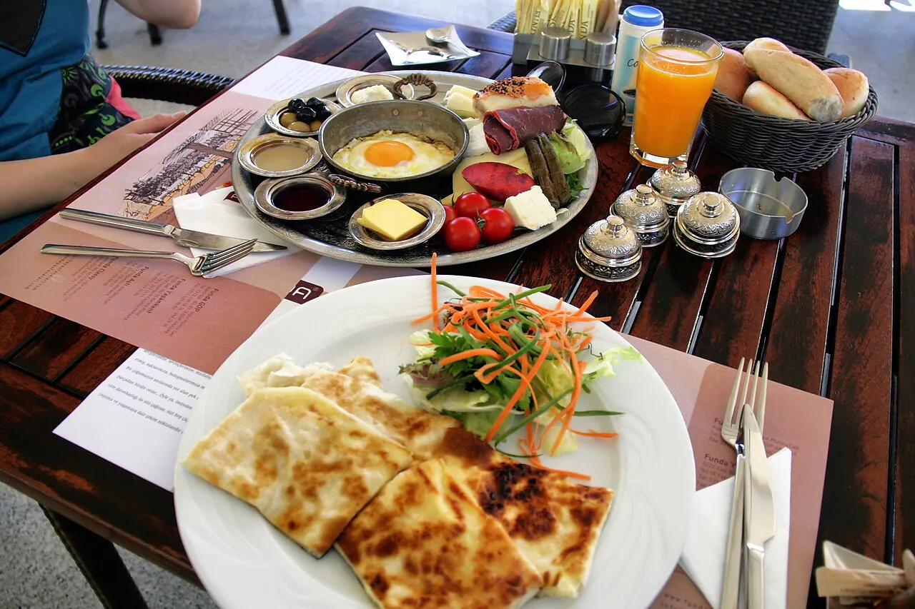 A Turkish breakfast with fried eggs, folded flatbread and small dishes of cheese and olives.