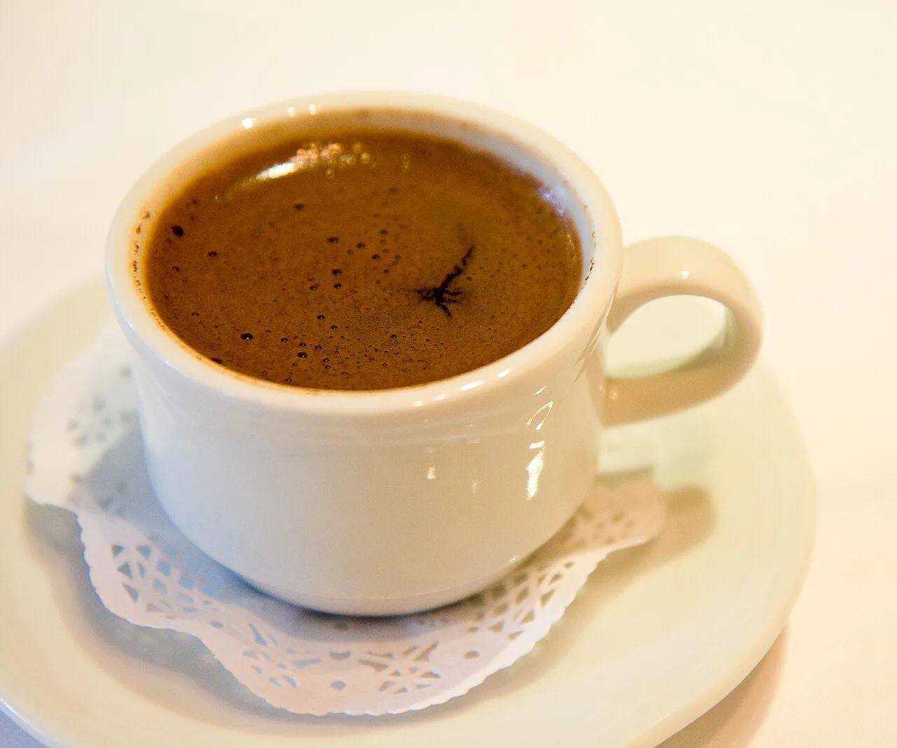 A cup of Turkish coffee with its foam on top.